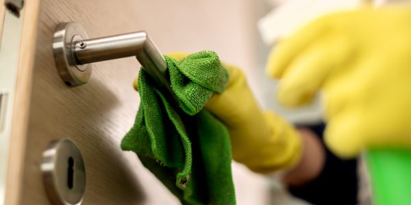 close up of unrecognizable person cleaning door handle.